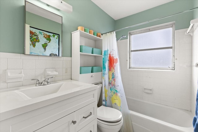 full bath featuring vanity, shower / bath combo, toilet, and tile walls