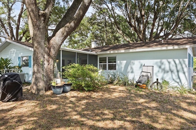 rear view of property featuring a sunroom