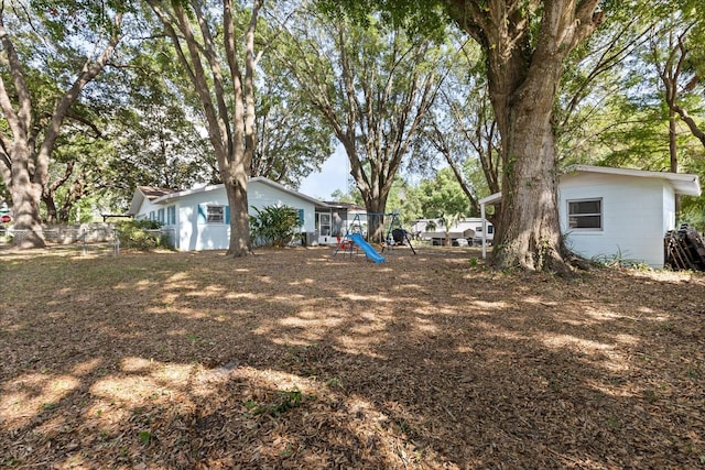 view of yard featuring a playground and fence