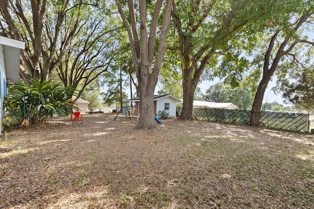 view of yard with a playground and fence