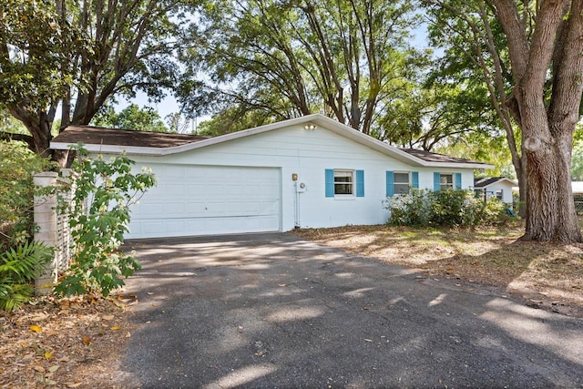 view of property exterior with a garage and aphalt driveway