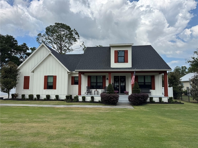 modern farmhouse featuring board and batten siding, a front yard, and covered porch