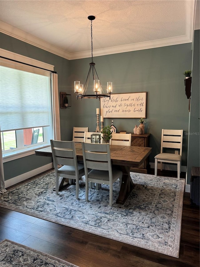 dining area with a chandelier, hardwood / wood-style flooring, crown molding, and baseboards