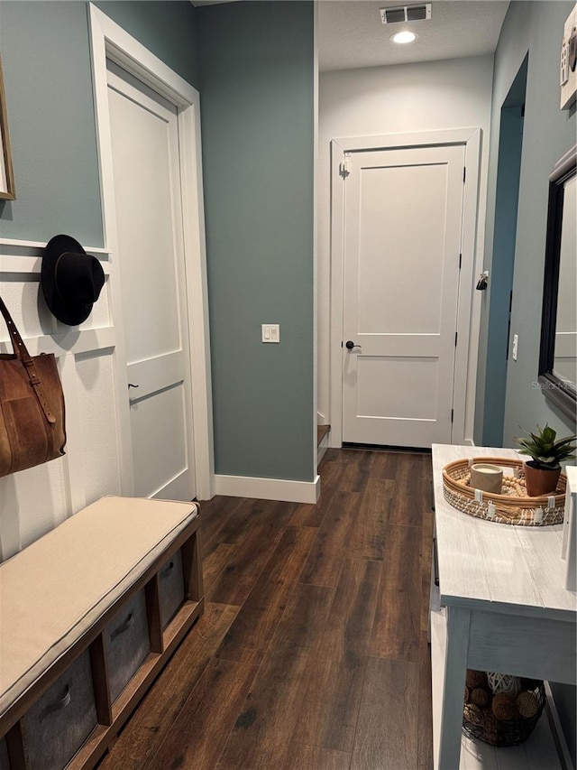 mudroom with dark wood-style flooring and baseboards