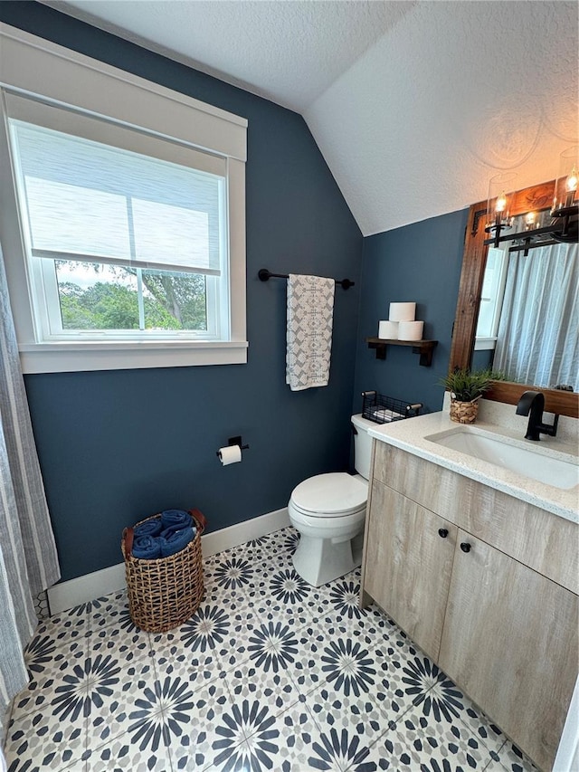 full bath with lofted ceiling, toilet, a textured ceiling, baseboards, and vanity