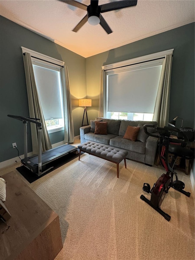 living area with carpet floors and ceiling fan