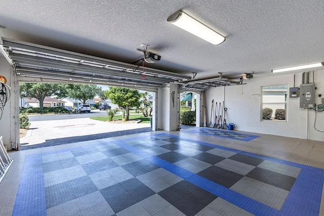garage with a garage door opener and electric panel