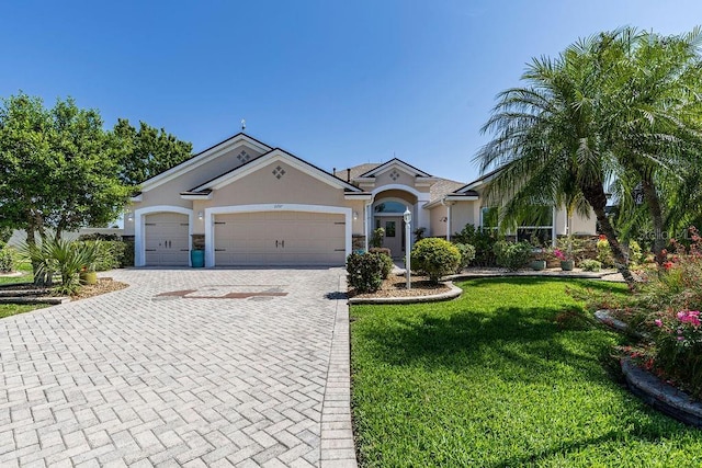 view of front of house with decorative driveway, a garage, a front lawn, and stucco siding