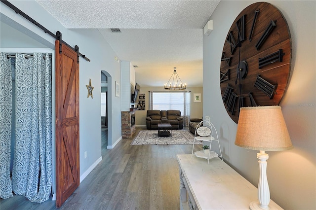 1451 Rosedale Way, The Villages, FL 32162 - corridor with a barn door, a textured ceiling, arched walkways, and wood finished floors