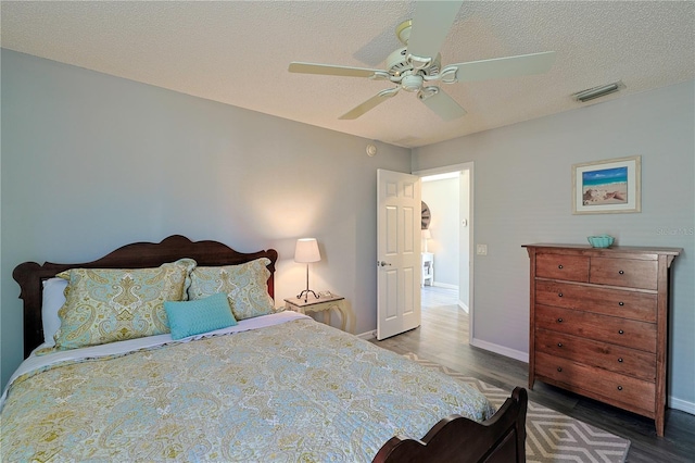 1451 Rosedale Way, The Villages, FL 32162 - bedroom featuring ceiling fan, a textured ceiling, visible vents, wood finished floors, and baseboards