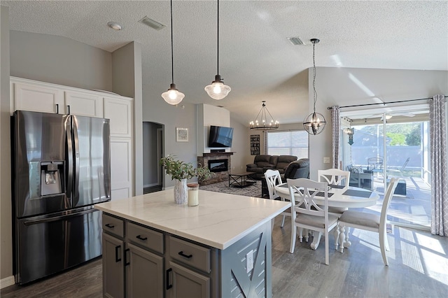 1451 Rosedale Way, The Villages, FL 32162 - kitchen featuring a glass covered fireplace, stainless steel fridge with ice dispenser, vaulted ceiling, and dark wood-type flooring