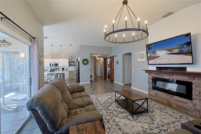 1451 Rosedale Way, The Villages, FL 32162 - living area featuring a notable chandelier, arched walkways, a stone fireplace, wood finished floors, and visible vents