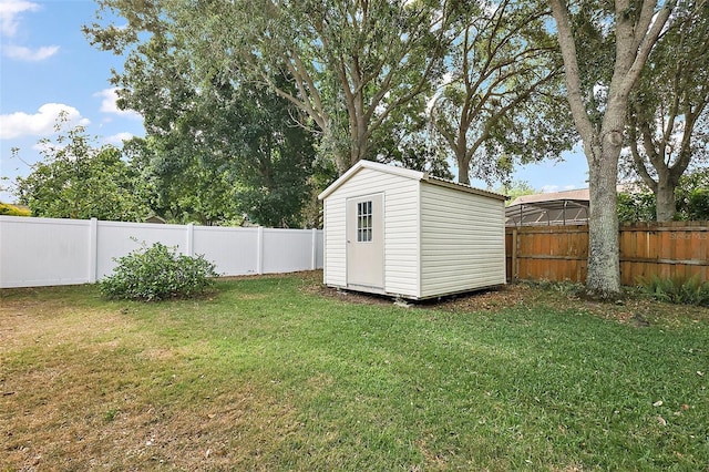 view of yard with an outdoor structure, a storage shed, and a fenced backyard