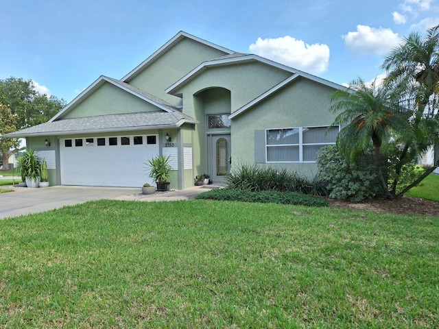 2750 Coral Reef Way, Tavares, FL 32778 - view of front facade featuring a garage, stucco siding, a front lawn, and driveway