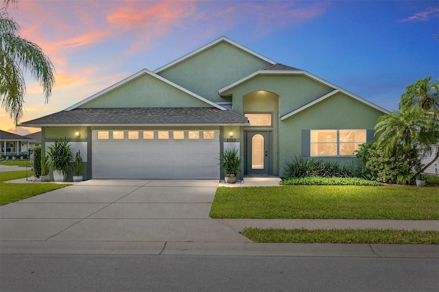 2750 Coral Reef Way, Tavares, FL 32778 - traditional home with a garage, stucco siding, a yard, and concrete driveway