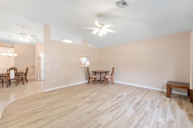 2750 Coral Reef Way, Tavares, FL 32778 - spare room with a ceiling fan, a chandelier, high vaulted ceiling, and light wood-type flooring