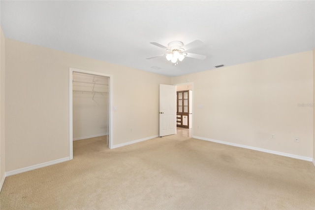 2750 Coral Reef Way, Tavares, FL 32778 - unfurnished bedroom featuring light colored carpet, a spacious closet, a closet, and ceiling fan