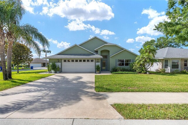 2750 Coral Reef Way, Tavares, FL 32778 - ranch-style home with an attached garage, concrete driveway, a front lawn, and stucco siding