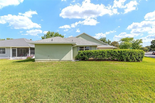 2750 Coral Reef Way, Tavares, FL 32778 - back of house with a sunroom, a lawn, and stucco siding