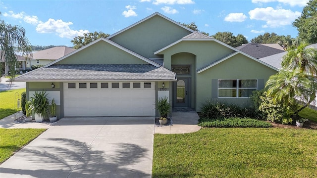 2750 Coral Reef Way, Tavares, FL 32778 - view of front of property with roof with shingles, an attached garage, stucco siding, and a front lawn