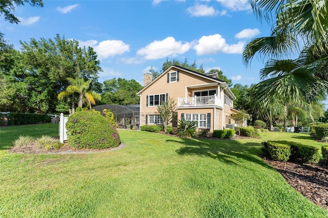 back of house with a lawn, a balcony, a chimney, and cooling unit