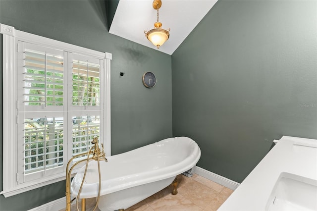full bathroom featuring a freestanding bath, baseboards, and a sink