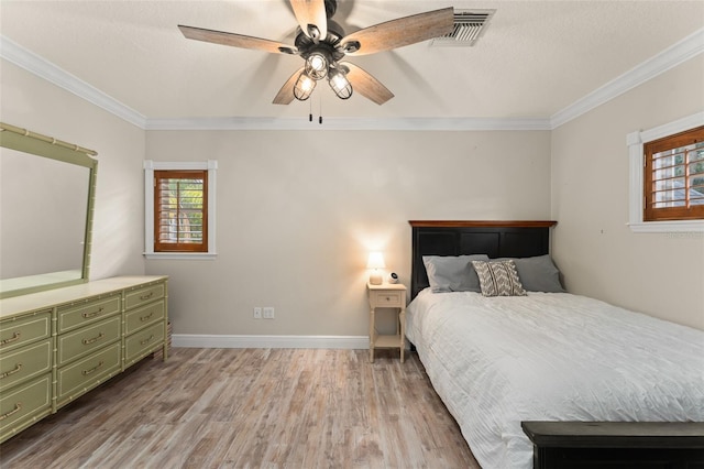 bedroom featuring visible vents, ornamental molding, wood finished floors, and multiple windows