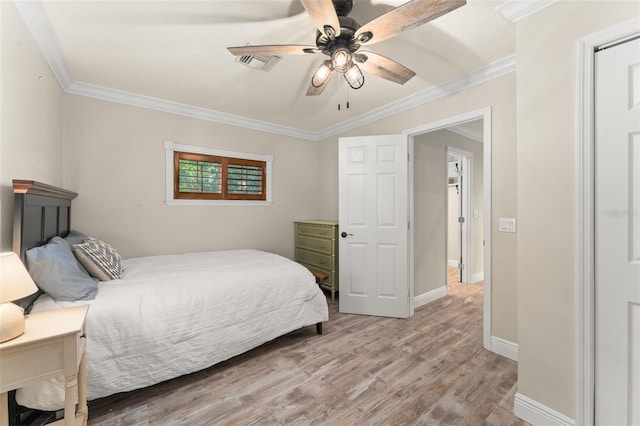 bedroom with ornamental molding, wood finished floors, and visible vents