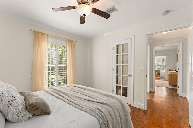 bedroom featuring ornamental molding, multiple windows, and wood finished floors