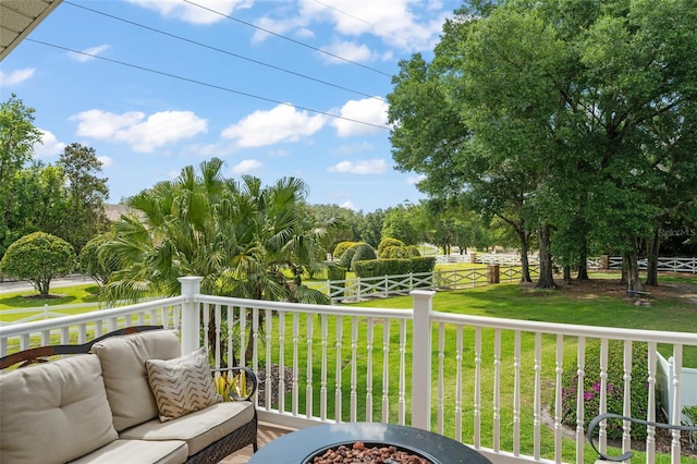 wooden terrace featuring an outdoor fire pit, fence, and a yard