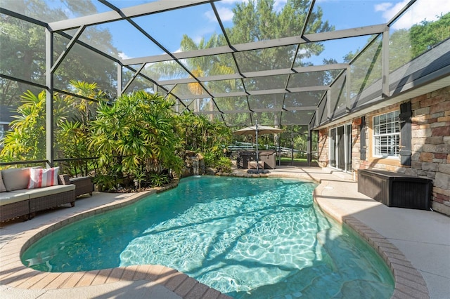outdoor pool with a patio, a hot tub, a lanai, and an outdoor hangout area