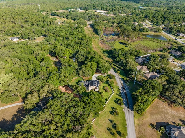 birds eye view of property with a water view and a view of trees