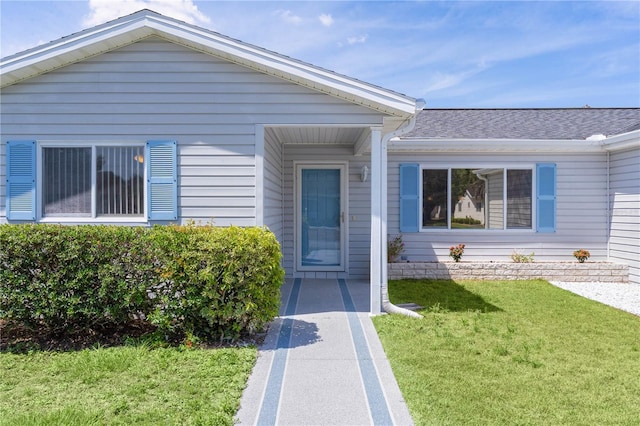 doorway to property with a lawn