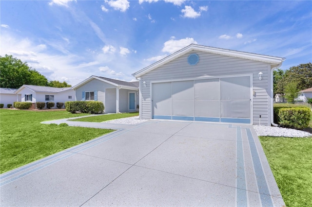 ranch-style home featuring concrete driveway and a front yard
