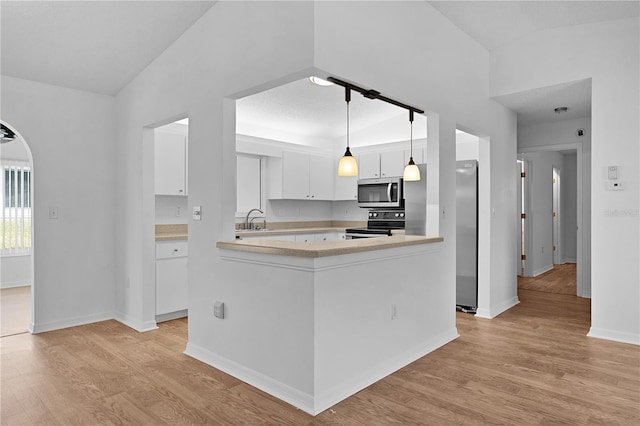 kitchen featuring range with electric cooktop, a sink, light countertops, stainless steel microwave, and light wood finished floors