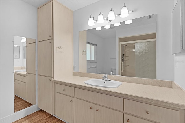 full bath featuring vanity, visible vents, wood finished floors, toilet, and a stall shower