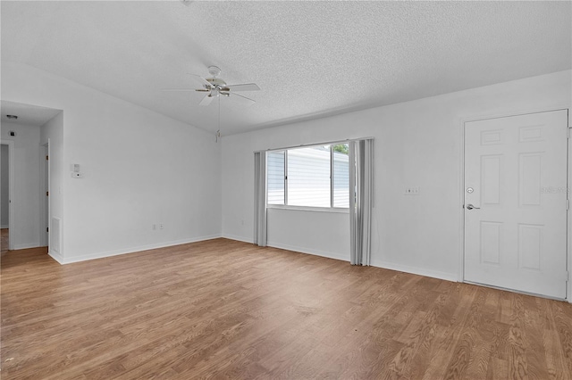 empty room featuring baseboards, a ceiling fan, light wood-style flooring, and a textured ceiling
