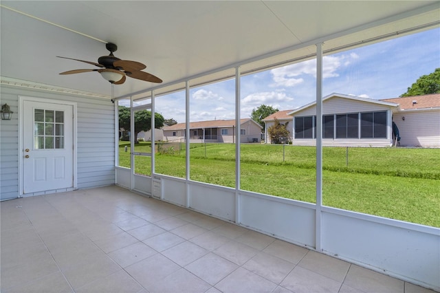unfurnished sunroom with ceiling fan
