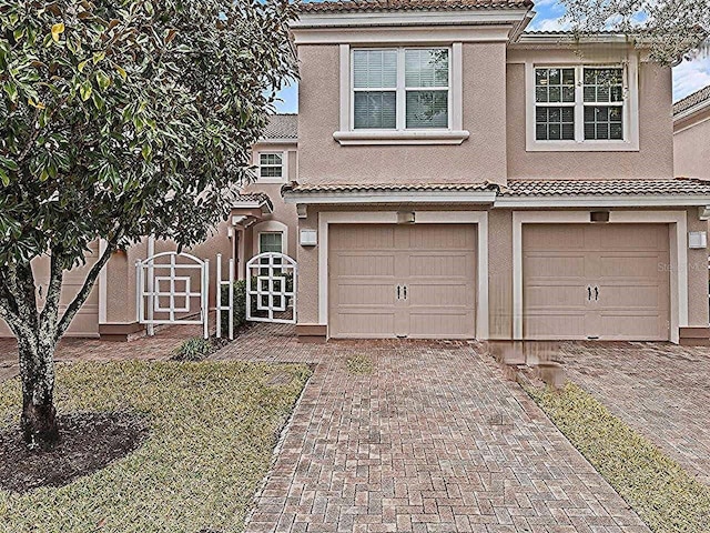 1288 Grady Ln, Davenport, FL 33896 - view of front facade with a tiled roof, driveway, stucco siding, and a garage