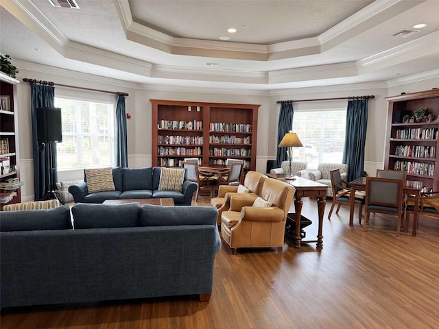 1288 Grady Ln, Davenport, FL 33896 - living room featuring a tray ceiling, crown molding, healthy amount of natural light, and wood finished floors