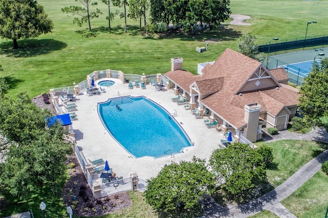 pool featuring a lawn, a patio, and fence