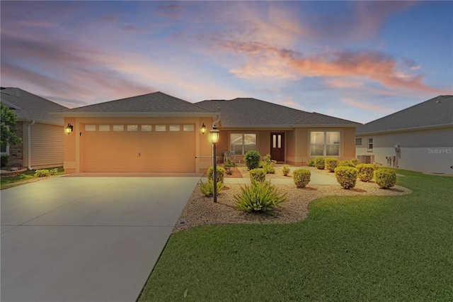 5596 Cedar Waxwing Dr, The Villages, FL 32163 - view of front facade with an attached garage, a yard, stucco siding, and driveway