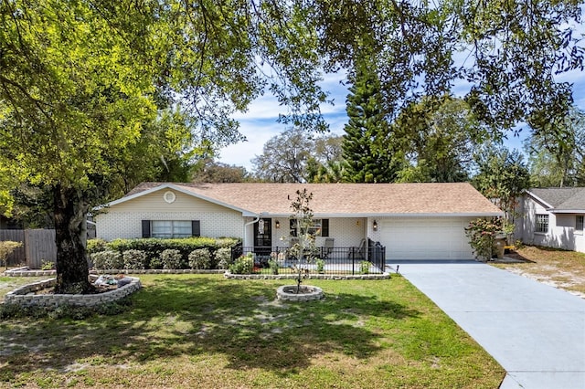 ranch-style house with fence, an attached garage, driveway, and a front lawn