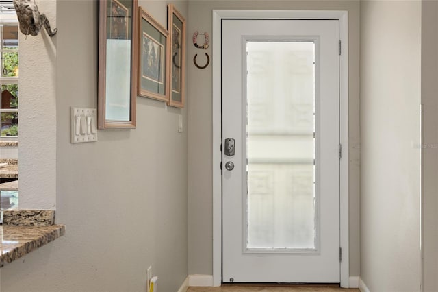 doorway to outside featuring baseboards