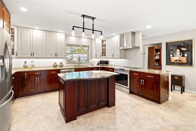 kitchen featuring stainless steel appliances, glass insert cabinets, wall chimney exhaust hood, and a center island