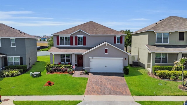 3441 Landing Vw, Tavares, FL 32778 - traditional-style house featuring decorative driveway, central AC unit, stucco siding, and a front lawn