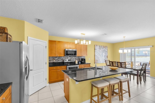 3441 Landing Vw, Tavares, FL 32778 - kitchen featuring appliances with stainless steel finishes, a chandelier, a sink, light tile patterned floors, and decorative backsplash
