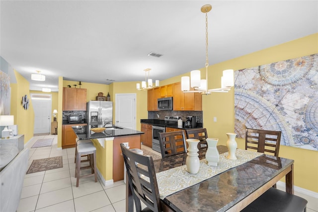 3441 Landing Vw, Tavares, FL 32778 - dining area with a chandelier, light tile patterned flooring, and baseboards
