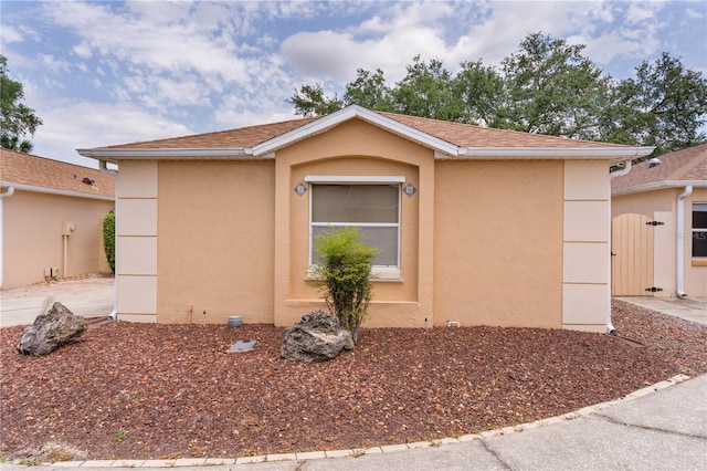 view of property exterior featuring a shingled roof and stucco siding
