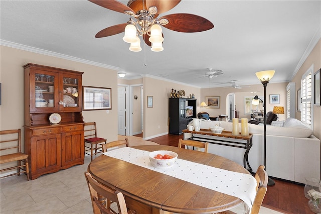 dining space with crown molding, light tile patterned floors, and a ceiling fan